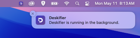 A Deskifier app in the macOS menu bar notifying that it keeps running in the background